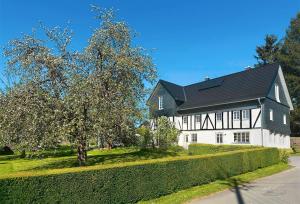 a black and white house with a tree in front of it at Fachwerkhaus Eiben in Kirchhundem