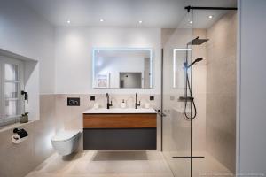 a bathroom with a toilet and a sink and a mirror at Fachwerkhaus Eiben in Kirchhundem +29 photos