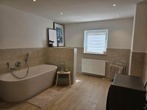 a large bathroom with a tub and a window at Haus Alb-Apfel in Apfelstetten +6 photos