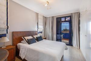 a bedroom with a large white bed and a window at Bahia Meloneras Luxury Duplex in Maspalomas +22 photos