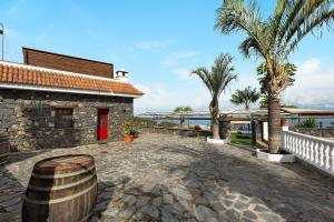 a building with a barrel in front of it with palm trees at Finca Viña Maria in Los Realejos