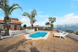a house with a swimming pool and a white chair at Finca Viña Maria in Los Realejos