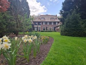 a garden with flowers in front of a house at Huize Beukenstein in Lochem