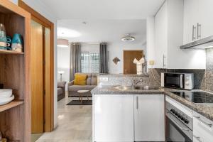 a kitchen with a sink and a living room at Malvarrosa A103 in Fuengirola