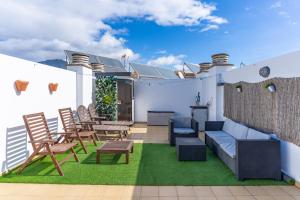 a patio with a couch and chairs on a roof at Malvarrosa A103 in Fuengirola