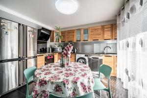 a kitchen with a table with flowers on it at Villa L'Oranaise in Cluses