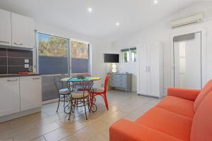 a living room with a orange couch and a table at Les Sables in Bormes-les-Mimosas