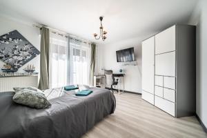 a bedroom with a large bed and a desk at Villa L'Oranaise in Cluses