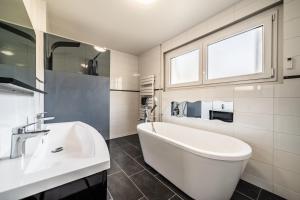 a white bathroom with a tub and a sink at Villa L'Oranaise in Cluses +28 photos