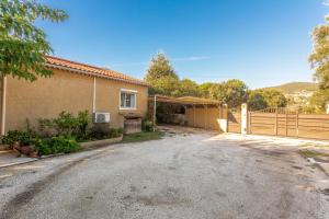 a house with a fence in front of a driveway at Les Sables in Bormes-les-Mimosas