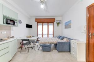 a room with a bed and a table and a kitchen at Franza 1 in Torre San Giovanni Ugento