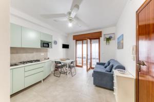a kitchen and living room with a couch and a table at Franza 1 in Torre San Giovanni Ugento +18 photos