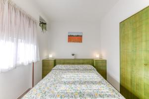 a bedroom with a bed with a green headboard at Franza 1 in Torre San Giovanni Ugento