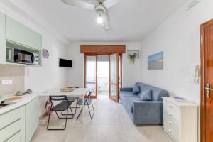 a kitchen and living room with a blue couch and a table at Franza 1 in Torre San Giovanni Ugento