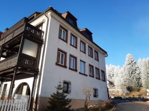 a white building with a fence in front of it at Kopf Frei auf 1000 Meter Wohnung 1 in Feldberg