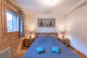 a bedroom with a blue bed and two night stands at App 6 pers cozy centre Samoëns in Samoëns +12 photos