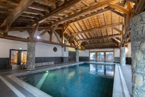a pool in a building with a wooden ceiling at App 6 pers cozy centre Samoëns in Samoëns