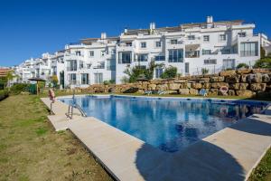 a swimming pool in front of a large building at Casa Maria Luisa in Manilva