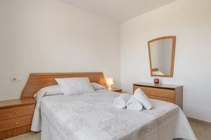 a bedroom with a bed with two white towels on it at Casa Boliches32 in Arcos de la Frontera