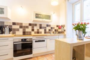 a kitchen with white cabinets and a counter with flowers at Maison de pêcheur au Rosmeur in Douarnenez +16 photos