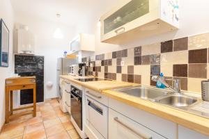 a kitchen with white cabinets and a sink at Maison de pêcheur au Rosmeur in Douarnenez