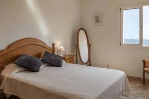 a bedroom with a white bed with a large mirror at Villa Granvista by Easy Brava in Calonge +9 photos
