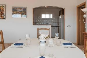 a white table with wine glasses and flowers on it at Villa Granvista by Easy Brava in Calonge