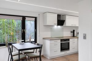 a kitchen with white cabinets and a table with chairs at Fewo Goldbach in Eschwege