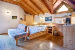 a bedroom with a bed and a chair at Lindenhof Apt 3 in Vandoies