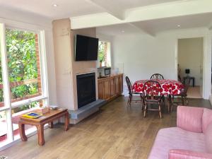 a living room with a table and a tv at Wildwood Lodge in Belgrave