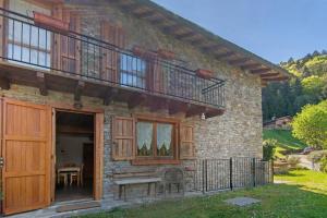 a brick house with wooden doors and a balcony at Piantina Holiday Home in Sacco