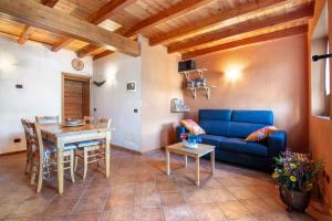 a living room with a blue couch and a table at Piantina Holiday Home in Sacco