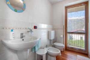 a bathroom with a sink and a toilet and a mirror at Piantina Holiday Home in Sacco
