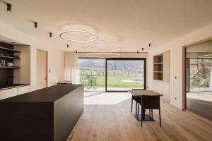 a kitchen with a black counter and a table at Trianglhof surrounded by vineyards in Bolzano