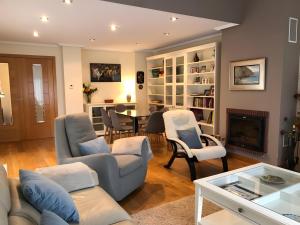a living room with a couch and chairs and a table at Casa La Marina in Llanes