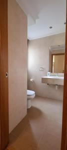 a bathroom with a toilet and a sink and a mirror at Casa La Marina in Llanes +18 photos