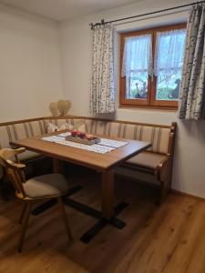 a dining room table with a bench and a table at Ferienwohnung Wetterstein in Mittenwald +12 photos