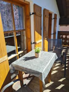 a table on a porch with a potted plant on it at Ferienwohnung Wetterstein in Mittenwald