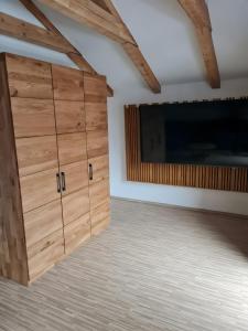 a room with wooden cabinets and a flat screen tv at Ferienwohnung Wetterstein in Mittenwald