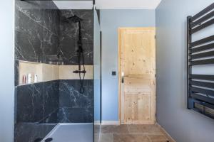 a bathroom with a shower with a glass door at La clé des Champs in Couffy