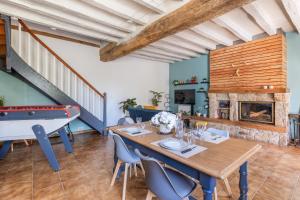 a dining room with a ping pong table and a fireplace at La clé des Champs in Couffy