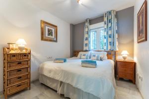 a bedroom with a bed and a dresser and a window at Mi capricho Beachfront Apt in Mijas +19 photos