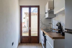a kitchen with a door leading to a balcony at Il Filo Azzurro Ulassai in Ulassai