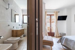 a bathroom with a sink and a toilet and a bed at Il Filo Azzurro Ulassai in Ulassai +53 photos