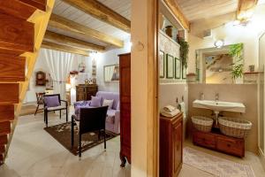 a bathroom with a sink and a living room at Alghero Old Town Gem - Sardinia in Alghero
