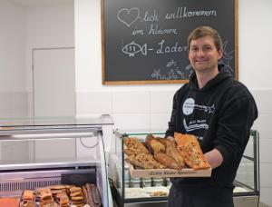 a man holding a box of pizza and bread at Ferienwohnung Barsch in Rade +10 photos