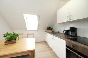 a kitchen with white cabinets and a wooden table at Ferienwohnung Barsch in Rade