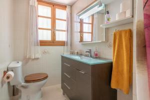 a bathroom with a toilet and a sink and a window at Villa Costa De Blanes in Calvià +17 photos