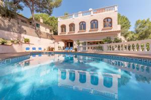 a swimming pool in front of a house at Villa Costa De Blanes in Calvià