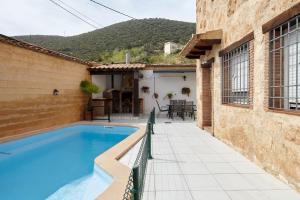 a house with a swimming pool next to a building at Casa Calera in Arbuniel